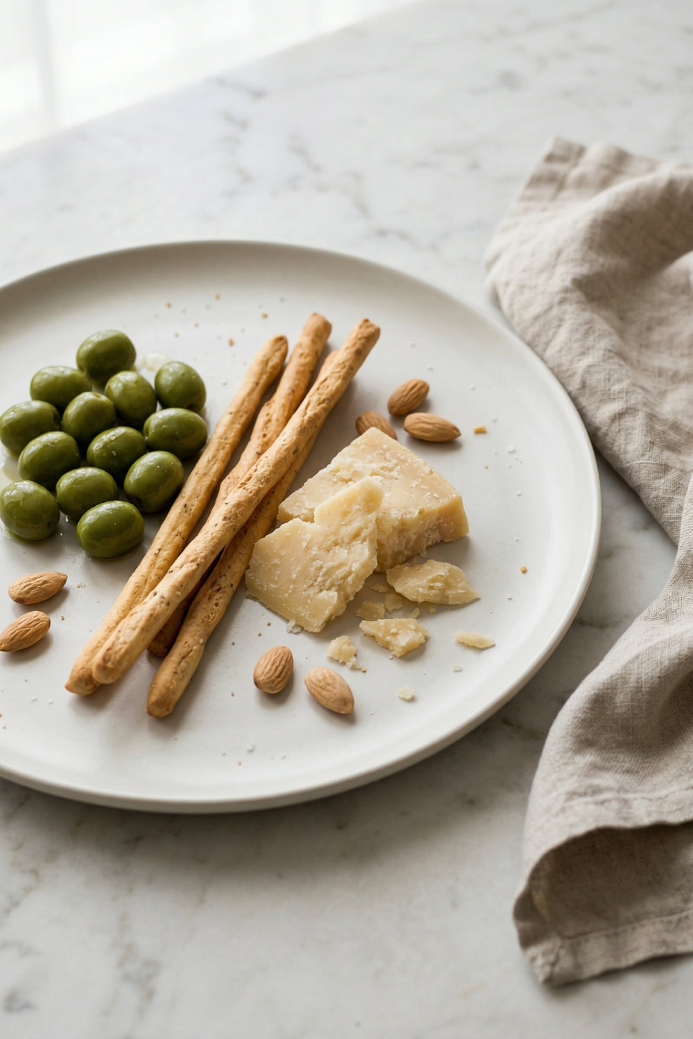 Perfekter Wein zum Aperitif – grüne Oliven, Grissini und Parmigiano Reggiano